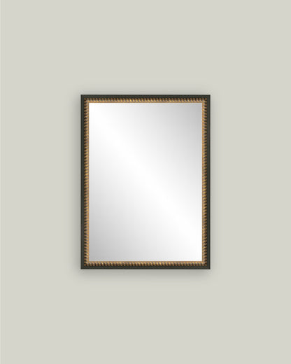 Rectangular mirror with a decorative gold frame on a light gray wall